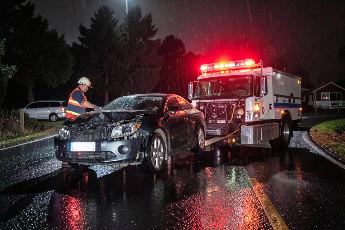 Tow truck operator loading a disabled car at night in Kawartha Lakes, Ontario